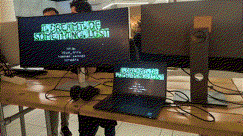 A dithered image of the I Dreamt of Something Lost title screen on a monitor-and-laptop setup.